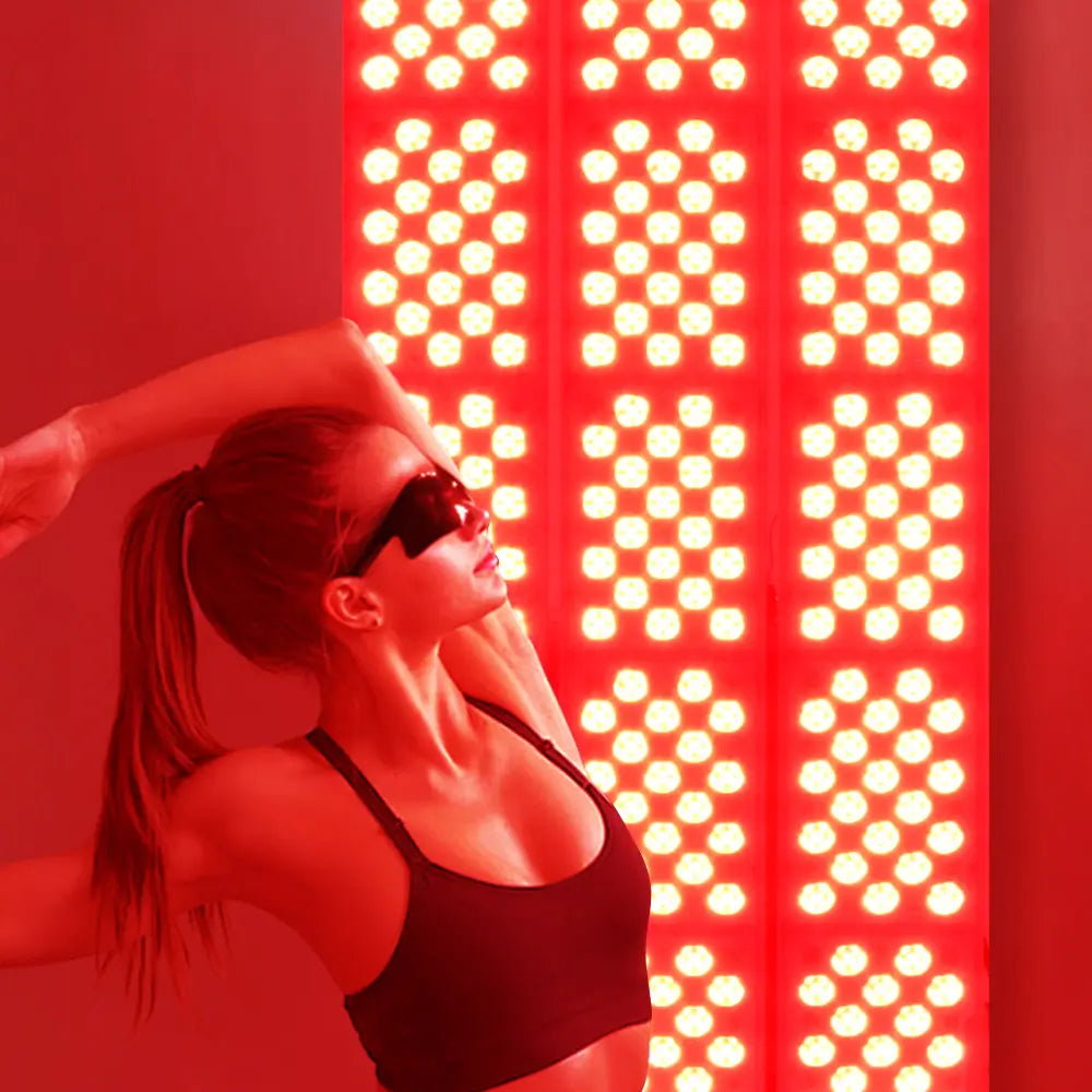 Woman wearing goggles using red light therapy panel