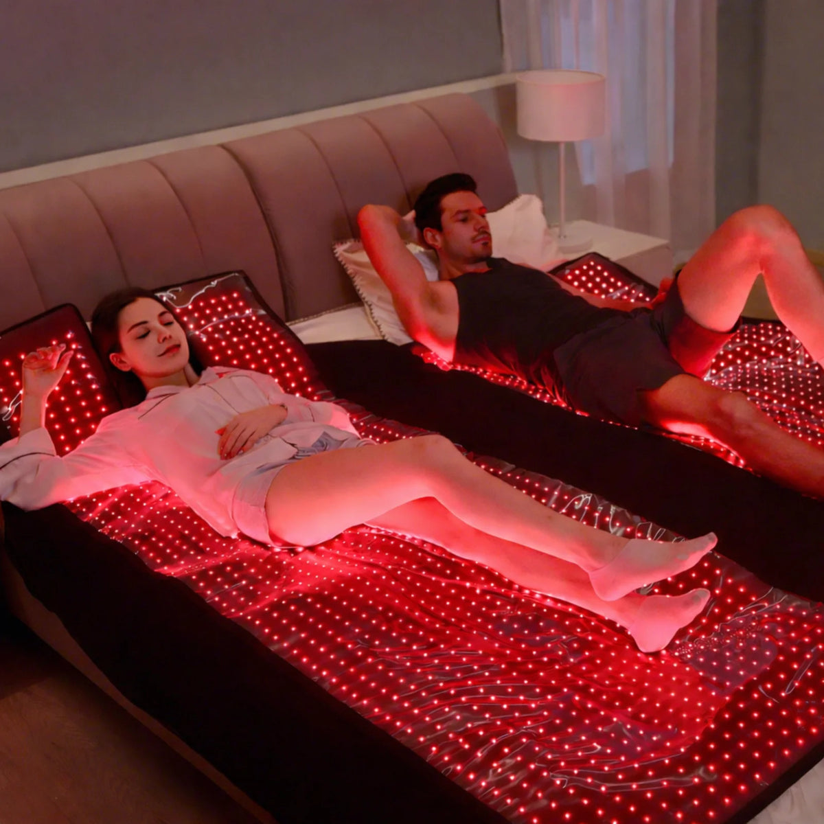 Couple using full-body laser and red light therapy sleeping bags in bed, glowing red