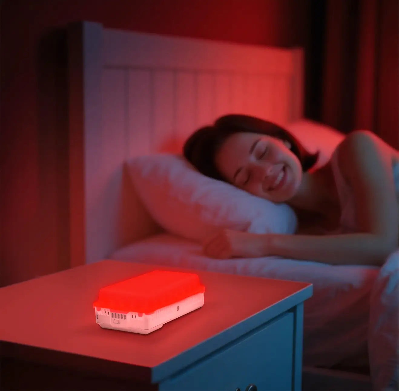 YouLumi Portable Red Light Panel on nightstand beside sleeping woman.