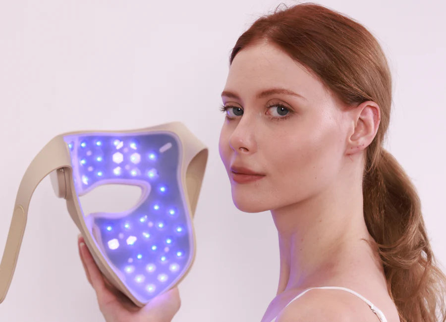 Model demonstrating Youlumi Y02 red light therapy mask with active blue LED lights