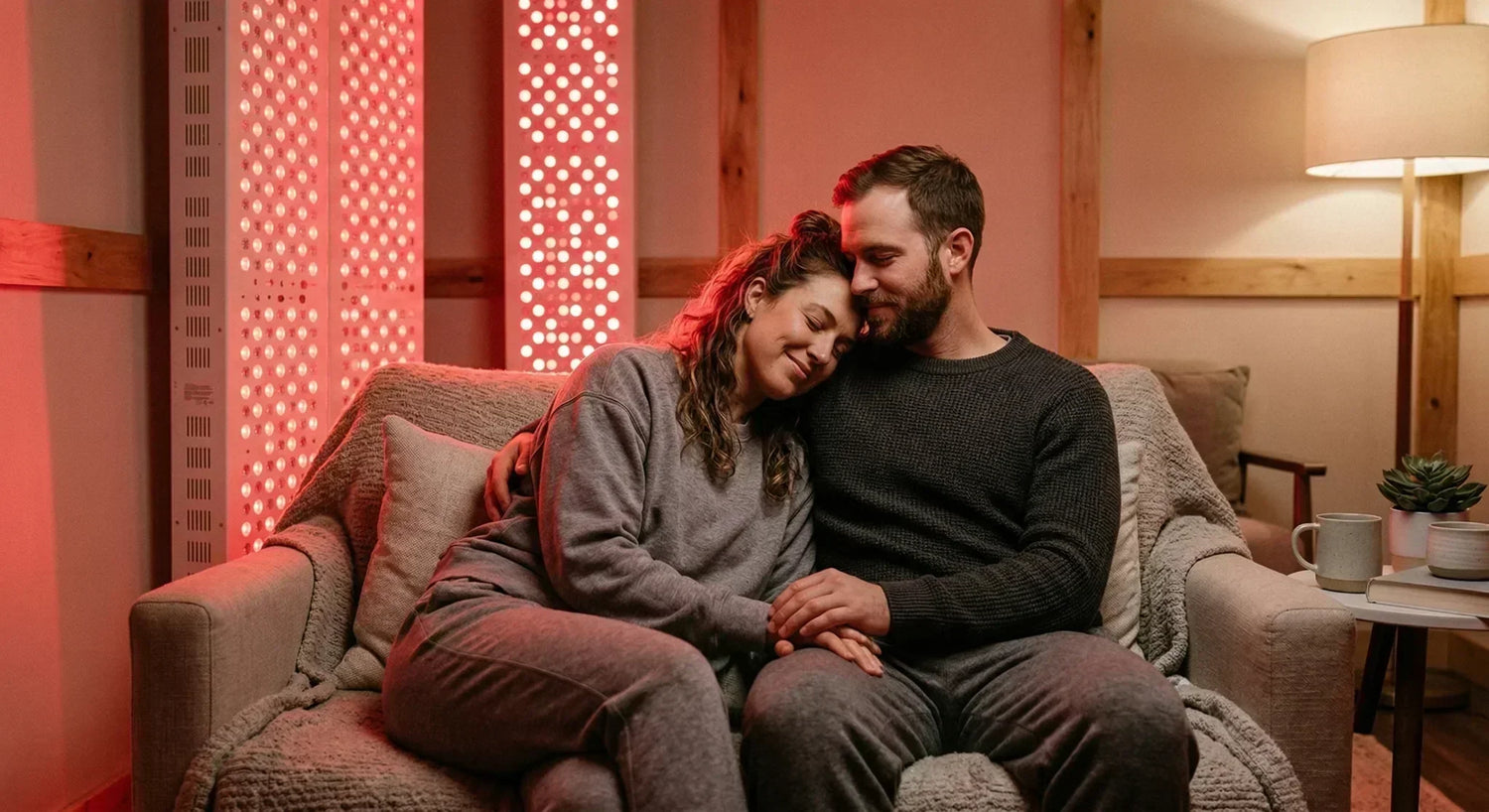 A relaxed couple sitting together in a warm red light therapy environment to improve mood and intimacy